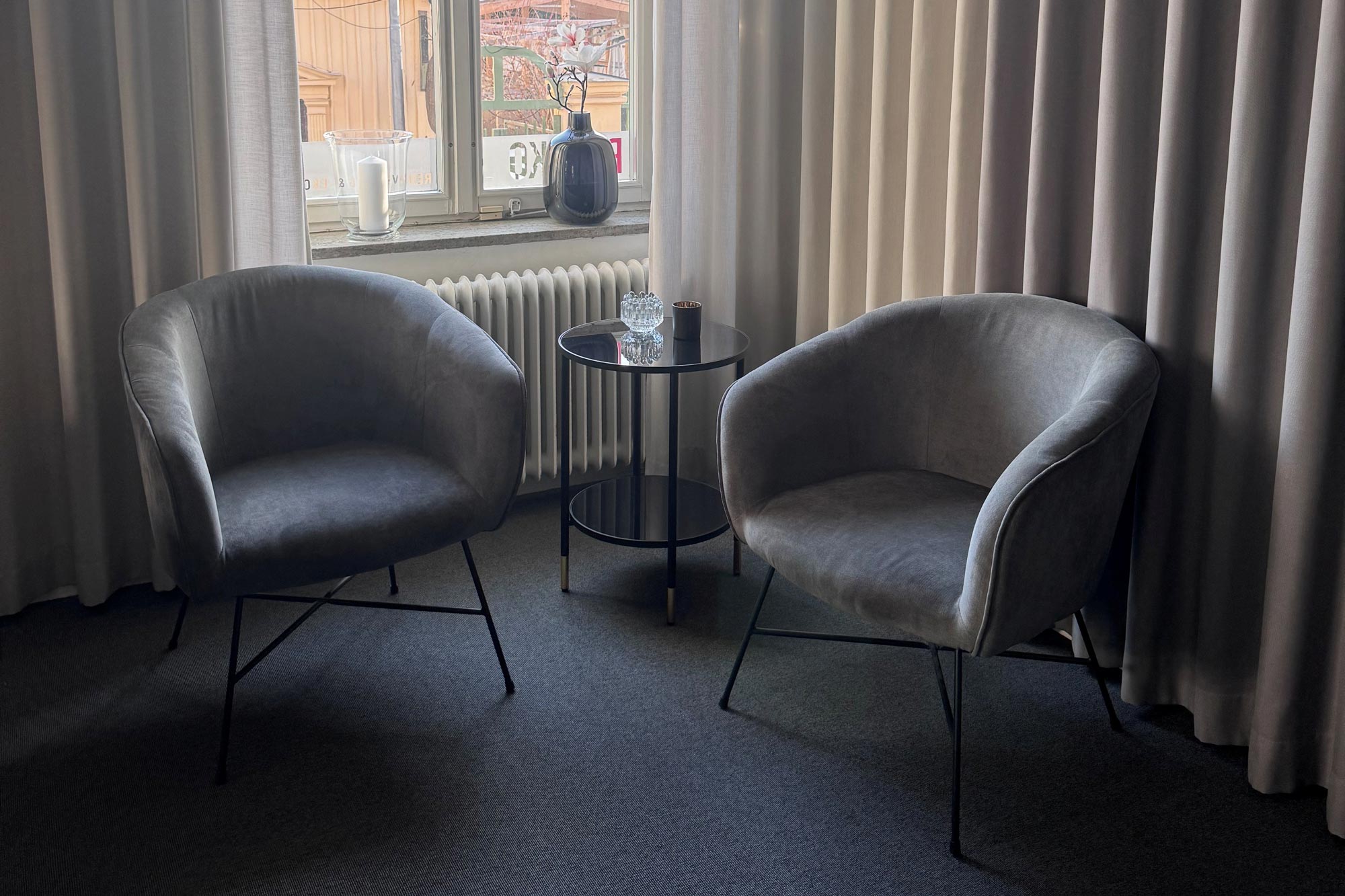 Två morderna fotöljer stående bredvid ett mindre bord