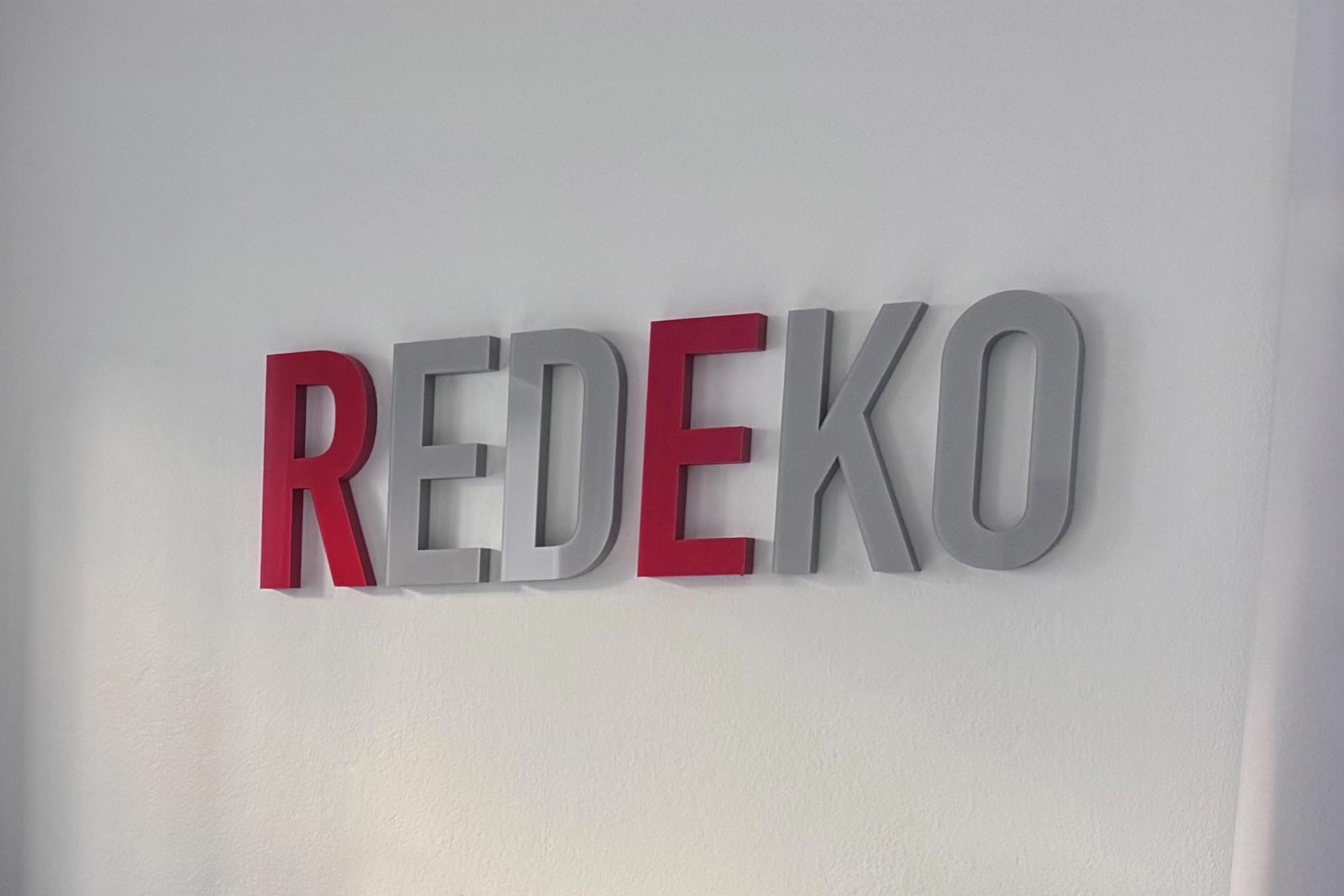 Företagsskylt med Redeko-logotyp inne på kontoret i Gävle